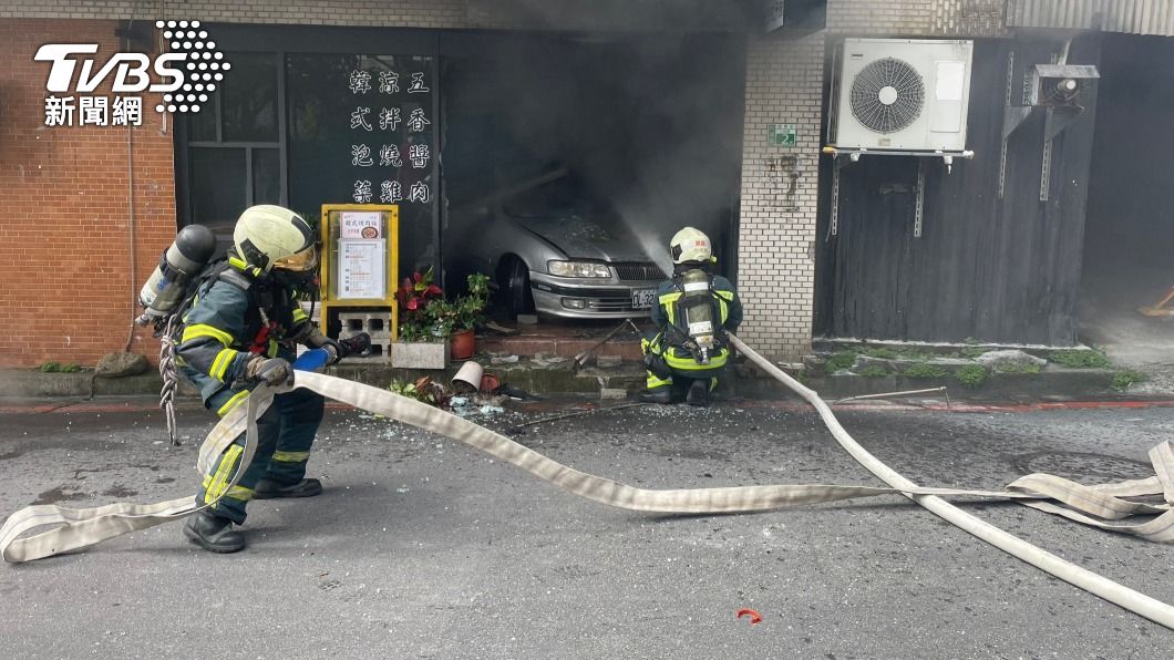 小轎車事故後倒車撞進餐廳內起火燃燒。（圖／TVBS）