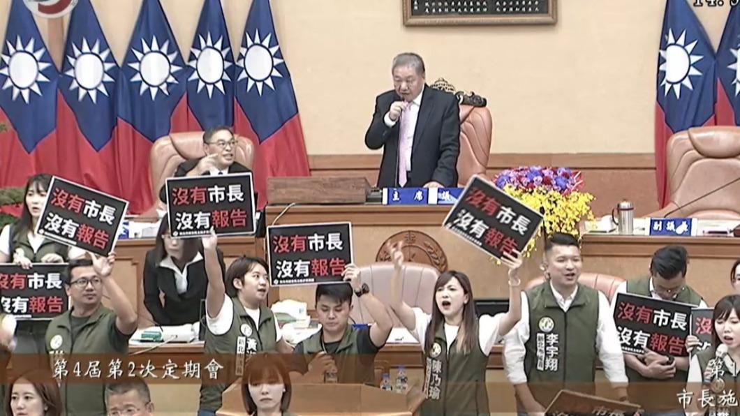 民進黨團霸占主席台，在議場舉牌抗議高喊，「沒有市長、沒有報告」。（圖／翻攝自新北市議會直播）