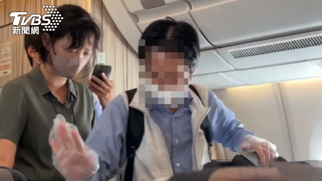 一名帶透明手套疑似是日本旅客不繫安全帶。（圖／TVBS）