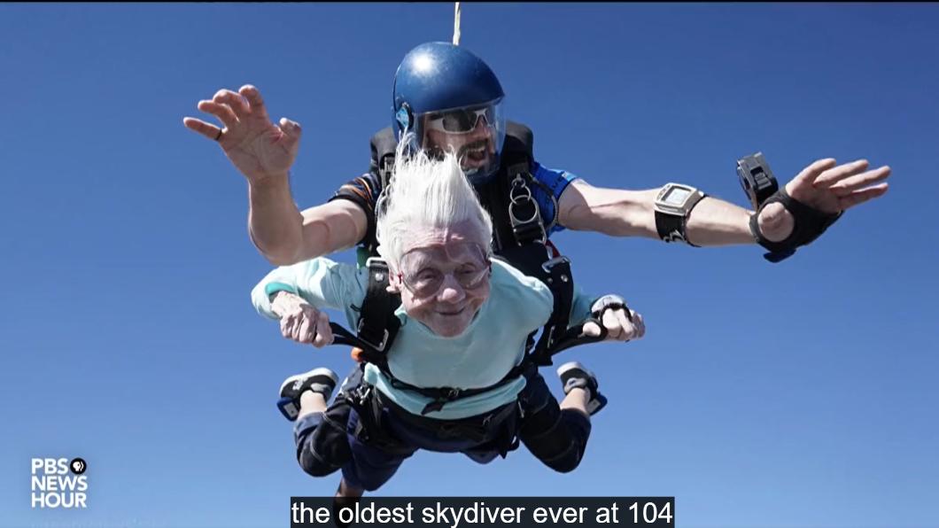 高齡104歲的人瑞奶奶桃樂希（白髮者），完成高空跳傘、成為金氏紀錄新保持人。（圖／翻攝自PBS新聞影片）