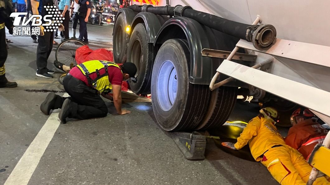 消防隊員發現騎士卡在輪胎底下。（圖／TVBS）