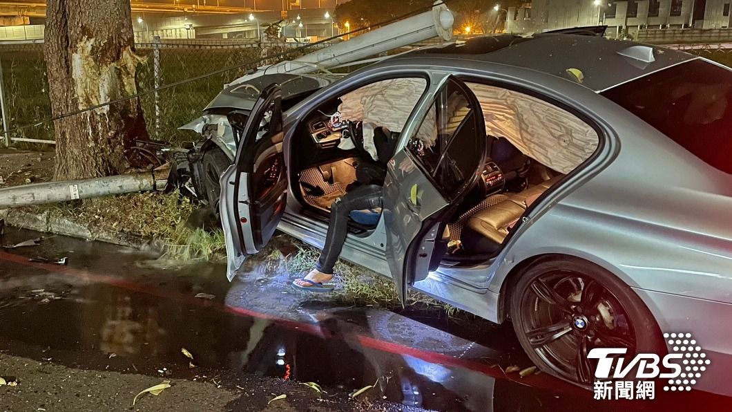 余男駕駛的BMW遭到擦撞後，失控偏移撞斷路邊燈桿。（圖／TVBS）