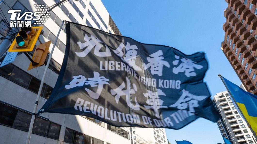 中國學生在英國約克大學畢業典禮講台上高舉「光復香港，時代革命」旗幟。（示意圖／shutterstock 達志影像）