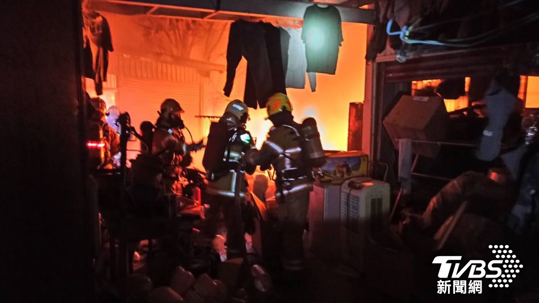 台南市永康區一間機車行倉庫驚傳火警，消防人員暗夜前往救火。（圖／TVBS）