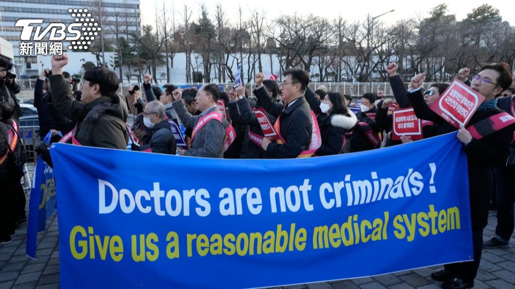 首爾總統府附近，抗議者在街上拉著「醫師不是罪人！給我們合理的醫療系統」布條。（圖／達志影像美聯社）