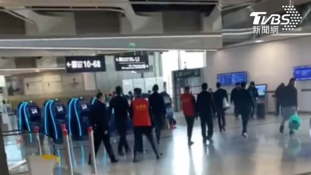 凌華湛遭中國使館員工與穿著紅色「愛心團」背心的工作人員遣送回國。（圖／中央社）