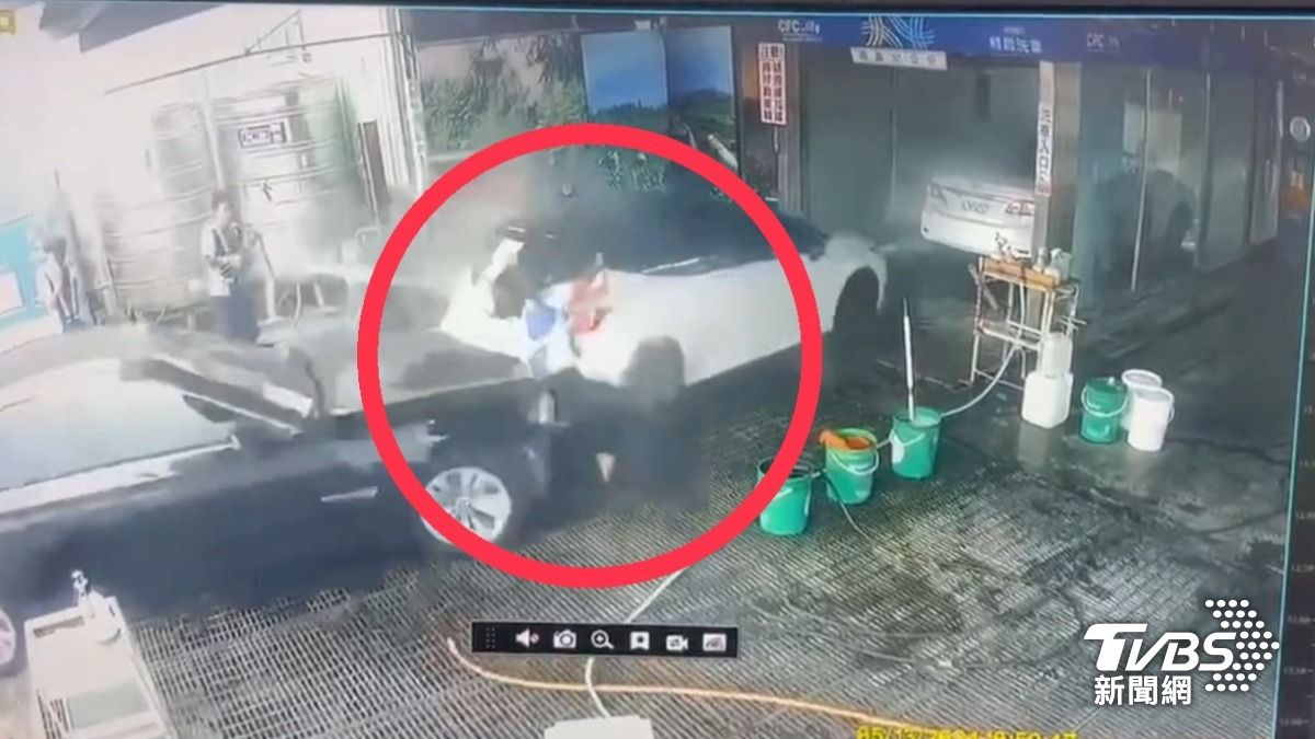 正在為顧客洗車的女員工遭撞。（圖／TVBS）