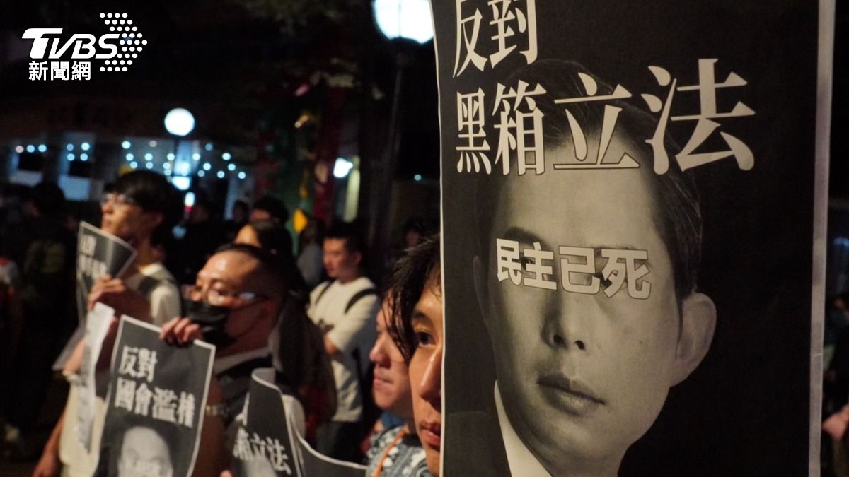 立院現場的抗議文宣，在黃國昌臉上寫「民主已死」。（圖／區國強攝）