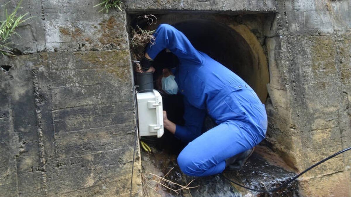 環境督察人員為蒐集工廠偷排廢水證據，辛苦安裝水質感測器。（圖／環管署提供）