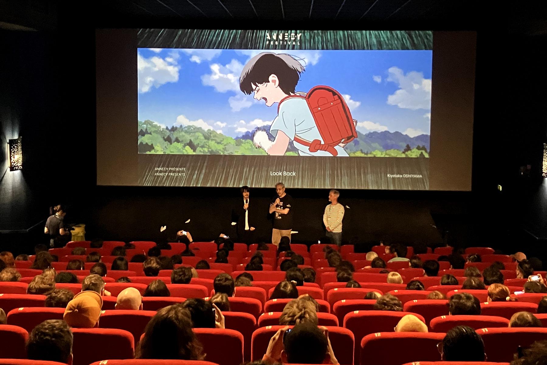 導演押山清高（銀幕前方左邊）現身安錫動畫影展，分享本片製作的幕後花絮。（圖／翻攝自《驀然回首》官方推特）