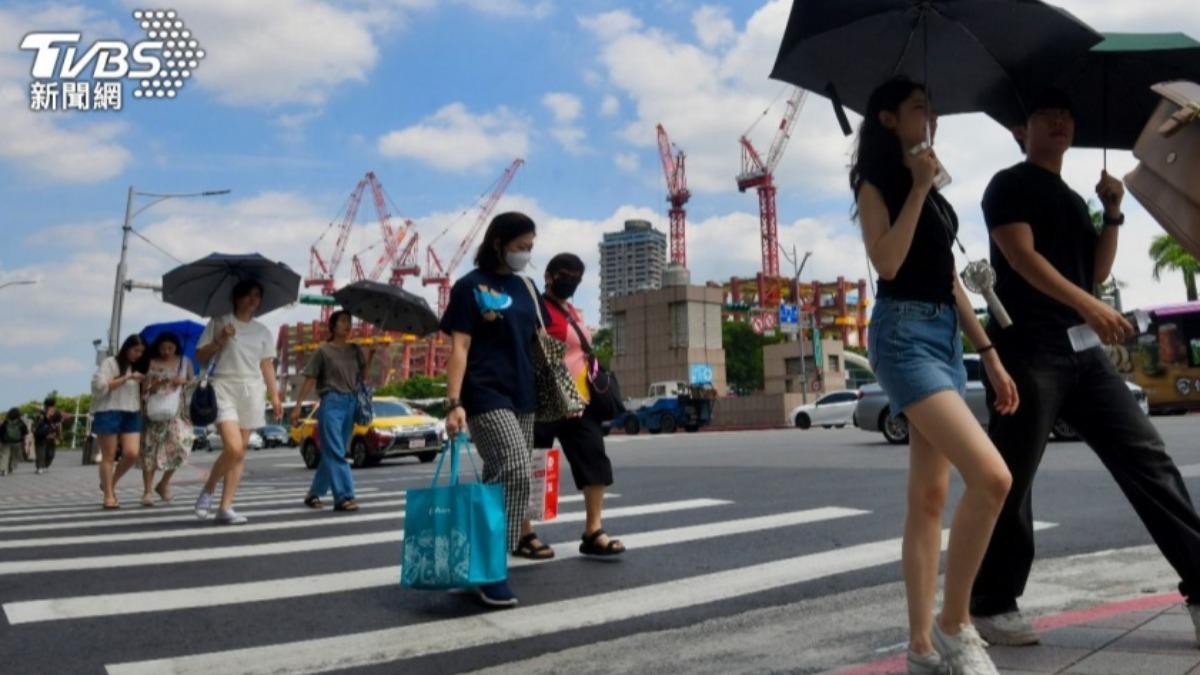 台北天氣炎熱，民眾撐陽傘遮陽。（圖／胡瑞麒攝）