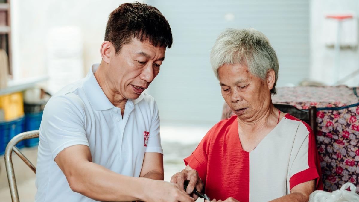 郭子乾（左）開車下鄉送愛心物資關懷弱勢長者憶親情。（圖／中華民國老人福利關懷協會提供）