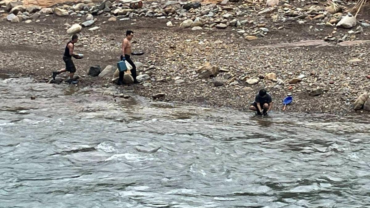 山陀兒颱風來襲，3名男子不顧危險在河邊淘金。（圖／民眾提供）