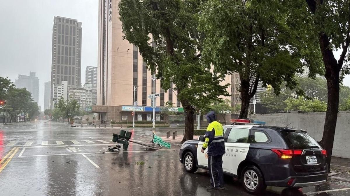 高雄3日上午風雨漸強，新興區中正四路與市中一路口號誌桿遭吹斷，員警到場管制。（圖／高市新興警分局提供）