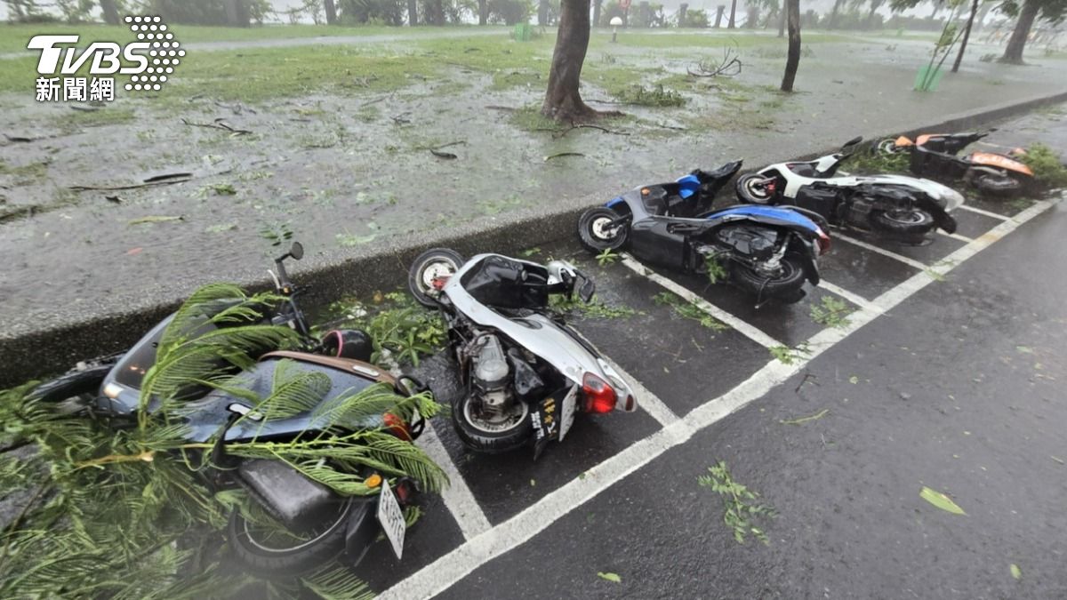 山陀兒風雨強勁，圖為高雄市區整排機車被吹倒。（圖／中央社）