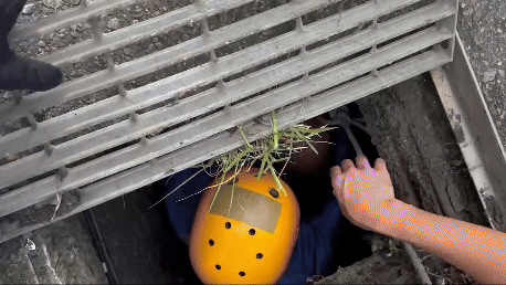 救援人員以工具翹開該處水溝蓋救出陳男。（圖／TVBS）