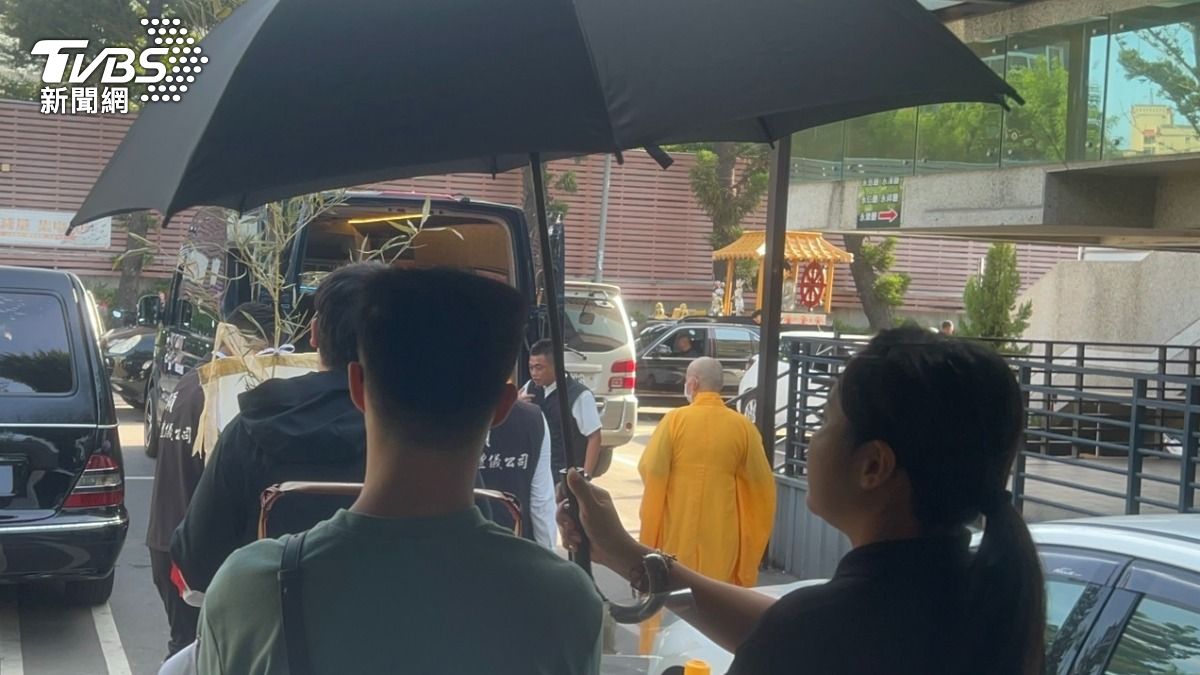 兩位同父異母、同母異父的哥哥，捧著黃童的照片，送黃童最後一程。（圖／林冠丞攝）