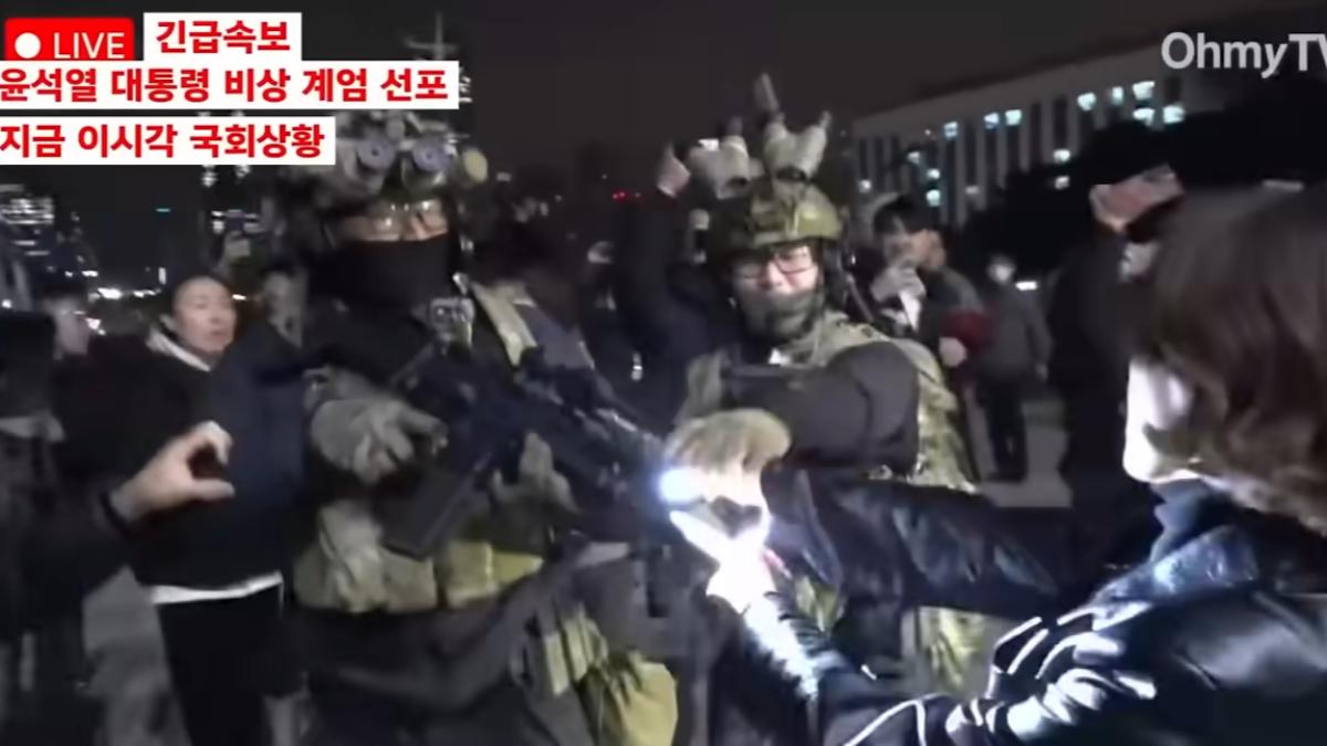 安貴朎握住戒嚴軍槍枝槍口。（圖／翻攝自X）