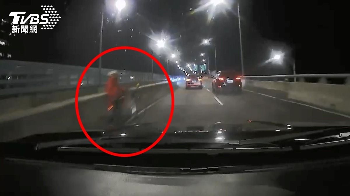 婦人牽腳踏車，受困洲美快速道路。（圖／TVBS）
