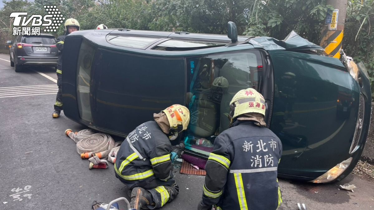 小轎車自撞翻覆，大批警消到場救援將受困的駕駛與乘客2人救出送醫。（圖／TVBS）