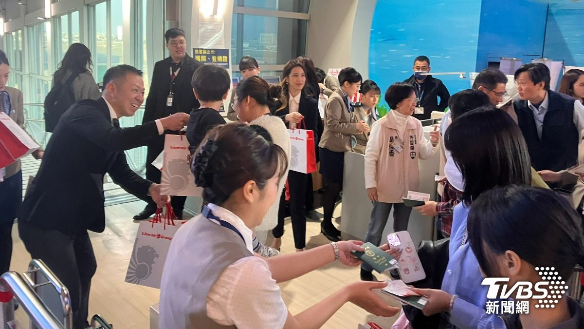 高閔琳及許智傑服務團隊在機場發上給首航旅客迎賓紀念品。（圖／林雅婷攝）