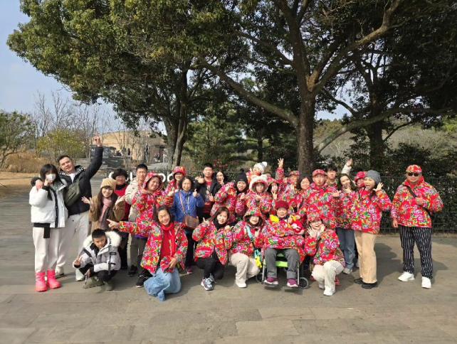 一家人穿著招牌大花制服合照。（圖／翻攝自「啟德機械起重工程-股公司」臉書）