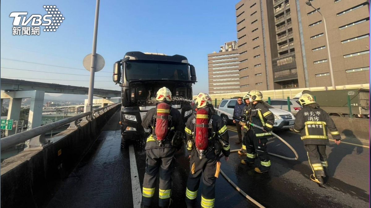 大貨車車頭不斷竄出濃煙，警消射水降溫。（圖／TVBS）