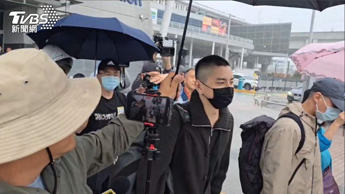 王大陸雨中獲得撐傘，露出一抹微笑。（圖／林冠丞攝）
