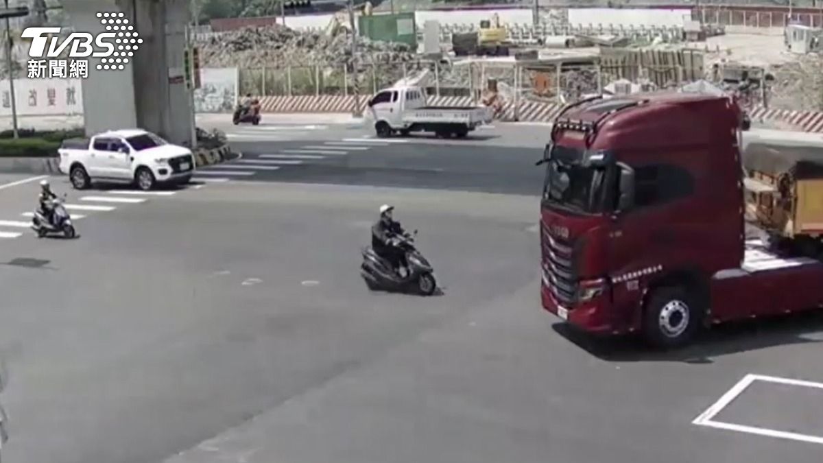 監視器拍下曳引車違規左轉與機車擦撞瞬間。（圖／TVBS）