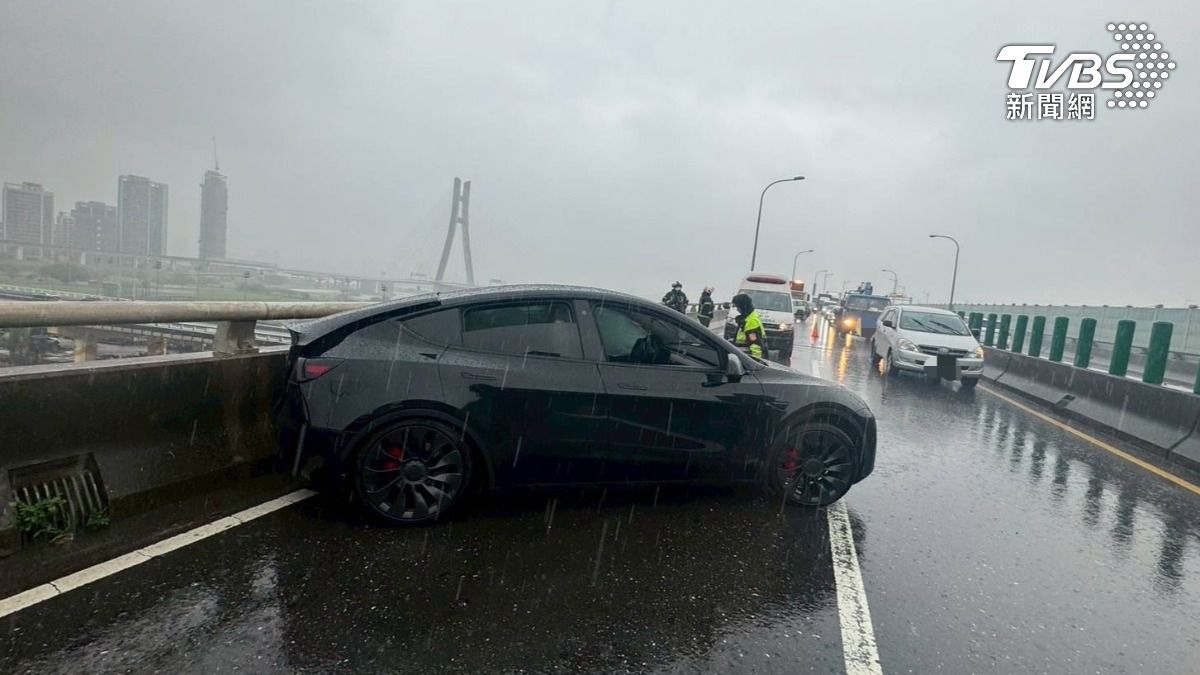 特斯拉疑似因天雨路滑自撞安全島。（圖／TVBS）