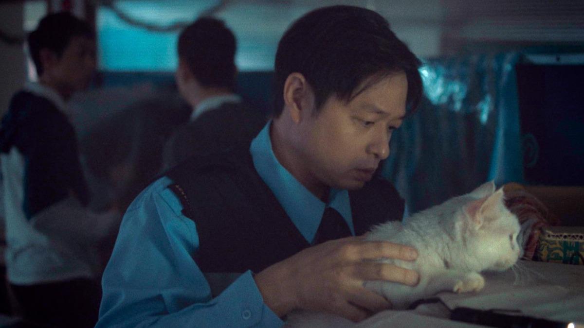 鄭有傑飾演的大樓管理員王國文意圖「抱緊處理」，貓咪卻從懷裡輕巧溜回紙箱。（圖／公視提供）