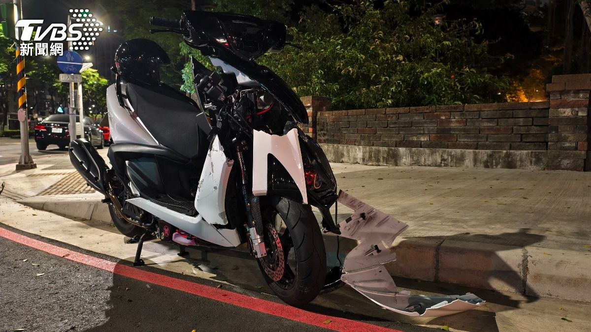蔡姓騎士的機車遭警方移置路旁，車體毀損嚴重。（圖／陳冠宇攝）