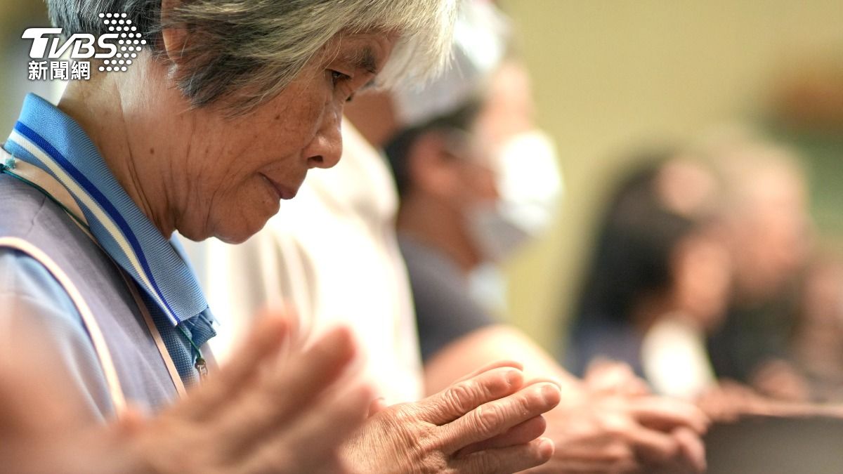 信眾虔誠雙手合十參與彌撒。(圖/區國強攝)