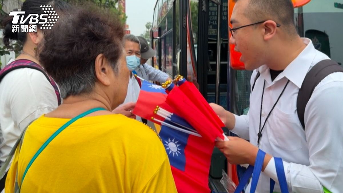 現場民眾領小國旗後上遊覽車。（圖／陳祁攝）