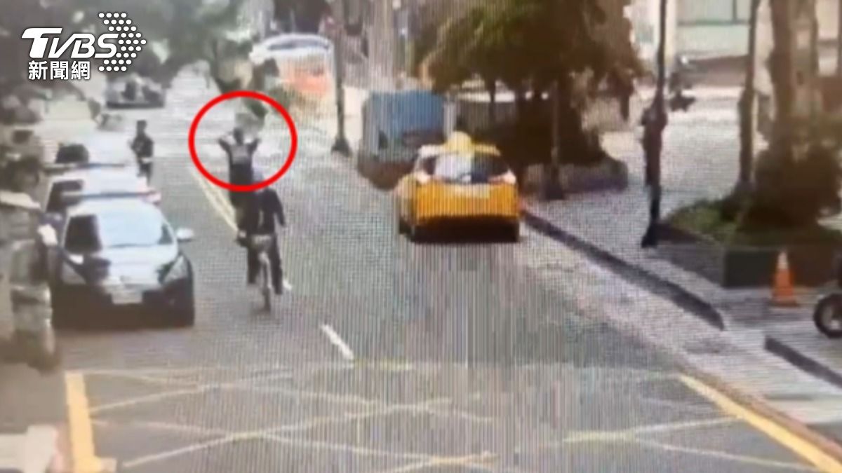 男子開完警車車門後，再走在路中央，行徑詭異。（圖／TVBS）