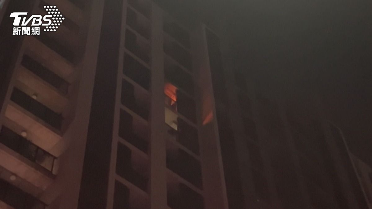 暗夜大樓陽台竄出紅色火光。（圖／廖文漢攝）