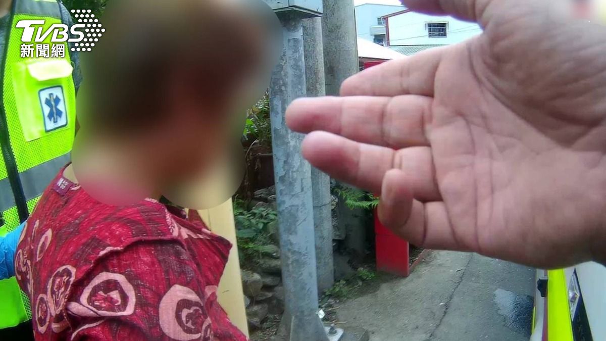 婦人情緒不穩,在路邊作勢自傷。(圖/TVBS)