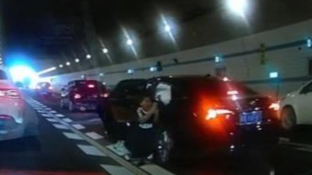 中國廣州傳出一起隧道內追撞事故，一名十歲男童跪地求路人救母親。　（圖／翻攝自極目新聞）