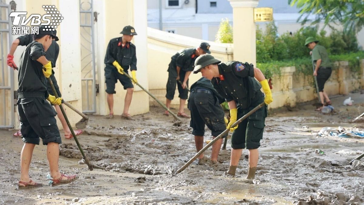 越南中部過去一週遭遇創紀錄的豪雨並釀成洪，圖為洪水退去後，越警進行清理工作。（圖／達志影像美聯社）