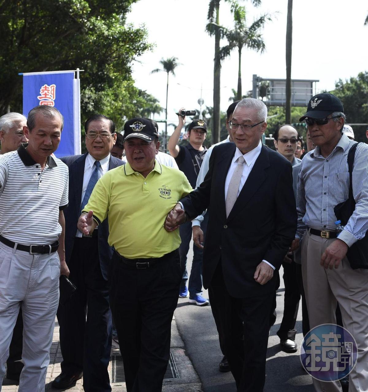 國民黨主席吳敦義最近身體不適，日前赴立法院為反年改團體「八百壯士」加油，還需八百壯士副指揮官吳斯懷攙扶。（翻攝臉書）